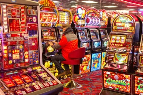 Jugador usando máquinas tragamonedas en un casino presencial