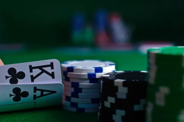 Jugador de póker observando sus cartas junto a fichas sobre la mesa
