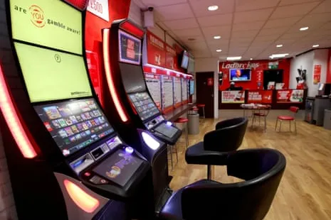 Interior de una casa de apuestas de Ladbrokes con máquinas y zona de asientos